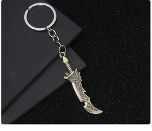Close-up of bronze-finish metal sword keychain with intricate textures on dark background