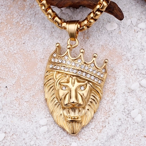 Detailed macro view of gold lion head pendant with crystal crown on white stones