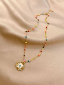 Gold daisy heart necklace with multicolored rhinestones and beads on beige satin