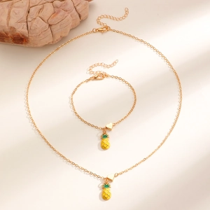 Dettaglio del set collana e bracciale con ciondolo a forma di ananas in oro e smalto