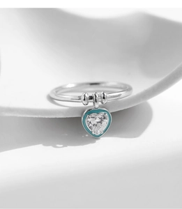 Macro shot of silver heart pendant ring with mint green enamel and sparkling gemstone