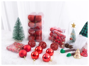 Detail of red Christmas ornaments with glitter and matte finishes on white plush