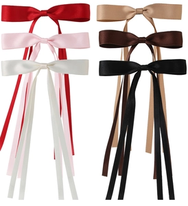 Detail view of satin bow hair clips in red, pink, beige, champagne, coffee, and black