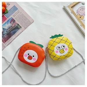 Detail of cute yellow and orange fruit-shaped mini crossbody bags for girls with leaf decor