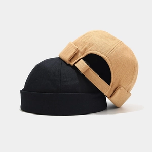Solid color docker hats in black and khaki with herringbone pattern and adjustable strap