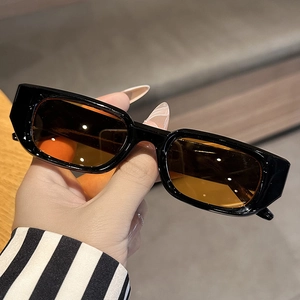 Macro shot of stylish black thick frame rectangular sunglasses with amber tinted lenses