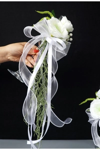 Detail of white artificial rose and green leaves on a bridal wedding toast glass