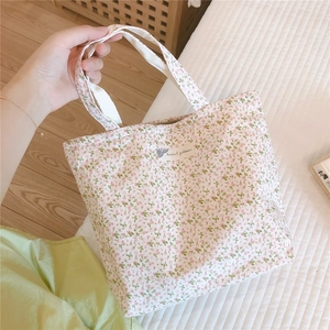 Vue détaillée d'un sac cabas en toile de coton fleurie avec une étiquette à motif animal