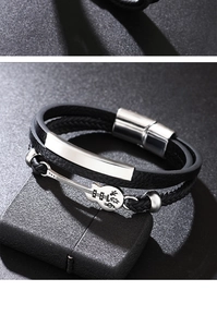 Detail of multilayer woven black leather bracelet with guitar charm and magnetic buckle