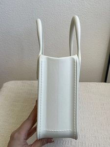 Detailed side view of white EVA handbag showing textured leather pattern and stitching