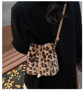 Detail of leopard print plush bucket bag with pearl drawstring and golden chain strap