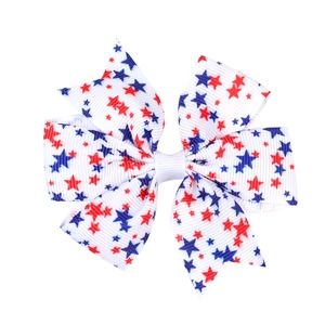 Detail of white grosgrain ribbon hair bow with red and blue star patterns for Independence Day