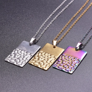 Vue détaillée de pendentifs rectangulaires avec texture martelée en or, argent et arc-en-ciel