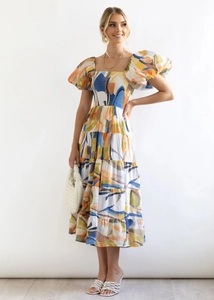 Detail of colorful abstract print tiered dress with square neck and puff sleeves