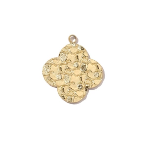 Close-up of golden four-leaf clover pendant with textured finish and hanging ring