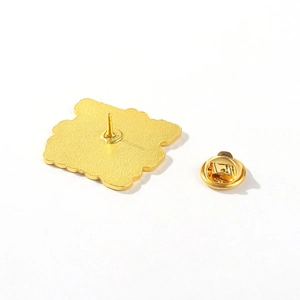 Detail of metal pin back with secure butterfly clutch and brushed golden finish texture