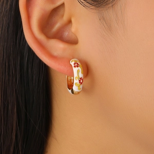 Close-up of floral enamel hoop earrings in vintage Chinese style on ear