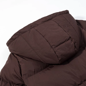 Detailed close-up of dark brown hooded puffer jacket featuring premium quilted stitching