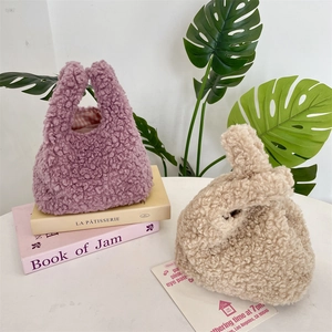Detailed close-up of plush faux fur wrist bags in purple and beige with checkered lining
