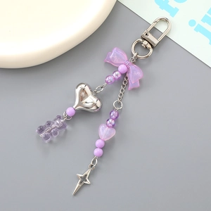 Detail of candy-colored bear and purple ribbon charms on a silver heart keychain