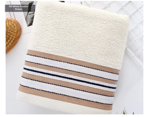 Detailed close-up of soft cotton towel with beige parallel stripes and loop texture