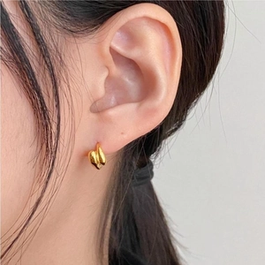Minimalist gold irregular curved stud earrings with polished mirror finish on model