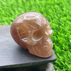 Macro shot of 7cm natural red-brown aura crystal skull with ice crack textures