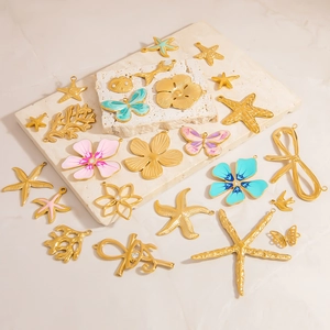 Detailed macro shot of assorted gold-plated ocean-themed DIY pendants on stone