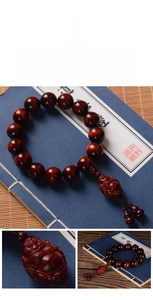 Macro detail of red sandalwood beads with a finely carved Maitreya Buddha pendant