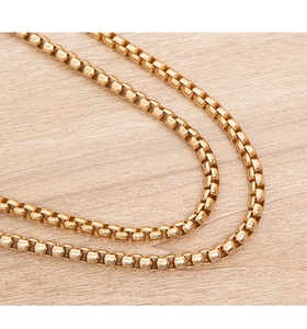 Detailed view of the elegant golden metal chain strap featuring a classic box link design