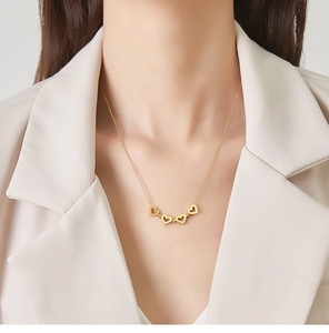 Collier en acier titane plaqué or 18 carats avec pendentifs cœurs sur un mannequin