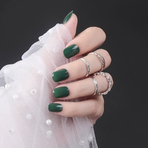 Short square-round dark green glossy press-on nails with silver decorative rings and pearls