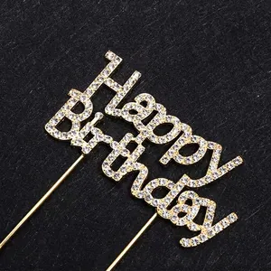 Golden Happy Birthday cake topper with rhinestones on dark textured background