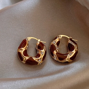 Vintage gold hoop earrings with brown enamel and diamonds on beige silk fabric