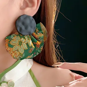 Deep green brocade fan-shaped earrings with gold floral embroidery and black hammered metal
