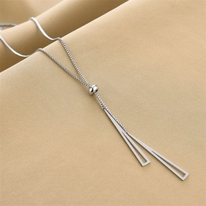 Detail of adjustable silver box chain with geometric triangle pendant on beige fabric