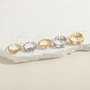 Set of five gold and silver minimalist heart rings displayed on a white podium