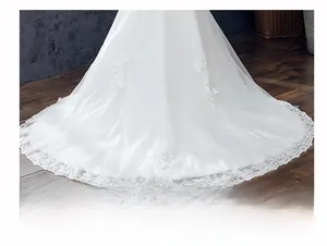Detail der weißen Meerjungfrau-Hochzeitskleid mit Spitze-Applikationen auf langer Tüllschleppe