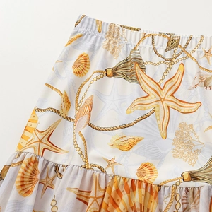 Detail of children's starfish print skirt featuring elastic waist and ruffled hemline
