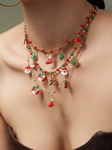 Gros plan du collier de Noël à trois rangs avec breloques Père Noël et sapin