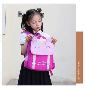 Detail of pink unicorn backpack for girls featuring 3D ears and colorful rainbow stripes