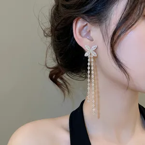Bow-knot earrings with long crystal tassels and silver plating on an Asian model