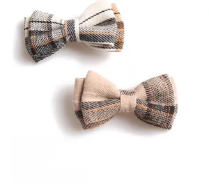 Close-up of premium tweed bow ties for pet collars in beige and brown plaid patterns