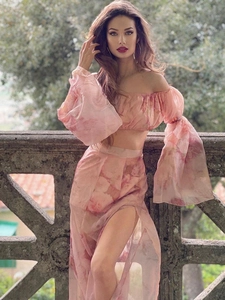 Detail of floral two-piece set featuring off-shoulder lantern sleeves and high slit skirt