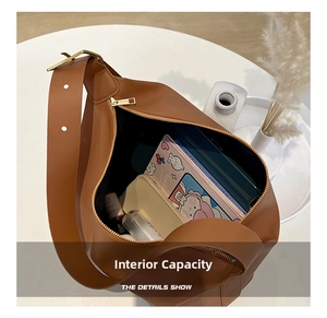 Detail showing internal capacity of the brown hobo bag with zip top and daily essentials