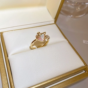 Detail of gold open ring featuring a heart-shaped stone and sparkling side accents