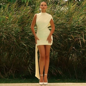 Detail of light yellow ruched mini dress showing asymmetric shoulder and flowy ribbon detail