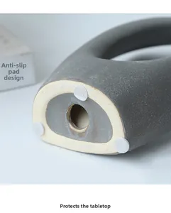 Dettaglio macro della base in ceramica opaca con tre gommini antiscivolo di protezione