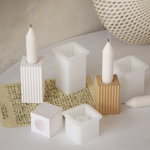 Close-up of ribbed square silicone molds and finished textured pillar candles