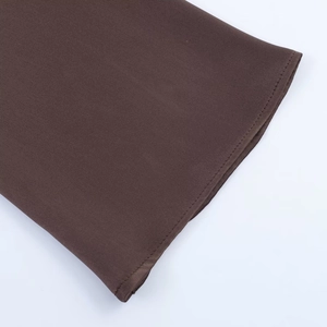 Detailed view of the dark brown satin dress featuring precise single-stitch hem finish